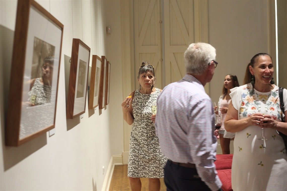image of visitors looking at exhibition opening of Mervyn Bishops show